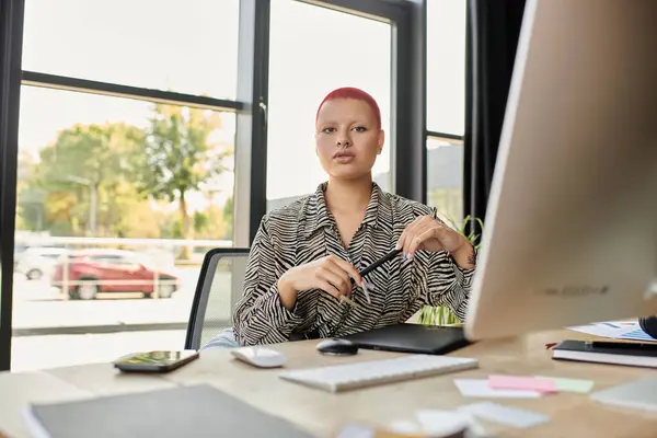 Une femme chauve en tenue chic s'arrête à son bureau dans un espace de travail inspirant. — Photo de stock