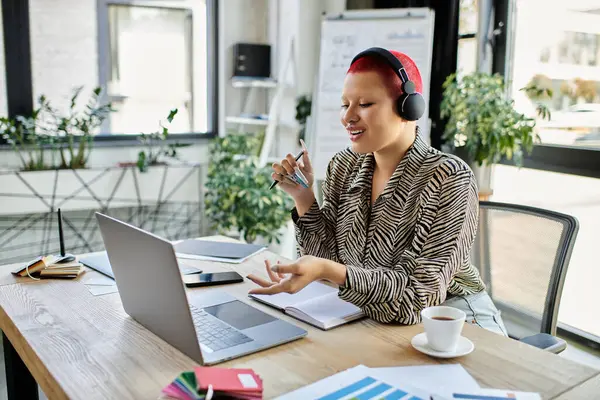 The bald woman in a patterned shirt enthusiastically speaks while working at her desk. — Stock Photo