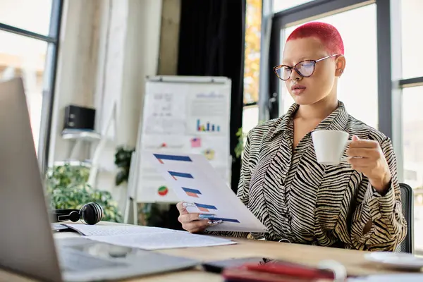 In a chic office, a bald woman with pink hair sips coffee while reviewing documents. — Stock Photo