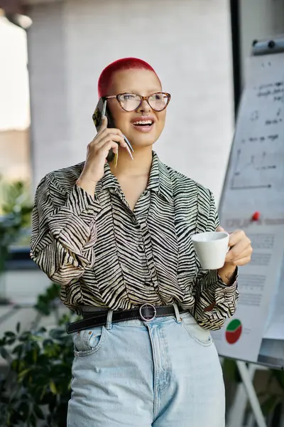 A stylish bald woman sips coffee and chats on the phone, advocating for a vibrant atmosphere. — Stock Photo