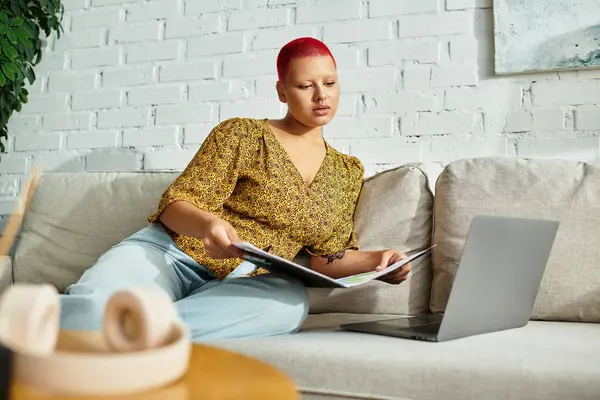 A beautiful bald woman focuses on her paperwork while relaxing in a modern, stylish space. — Stock Photo