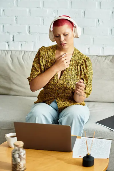 A beautiful bald woman with headphones immerses herself in music while working from home. — Stock Photo