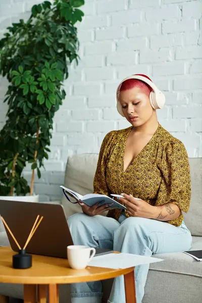 She relaxes on a cozy couch, immersed in her book, surrounded by greenery and tranquility. — Stock Photo
