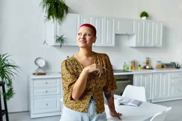 A confident bald woman with red hair stands in a stylish kitchen, deep in thought. — Stock Photo