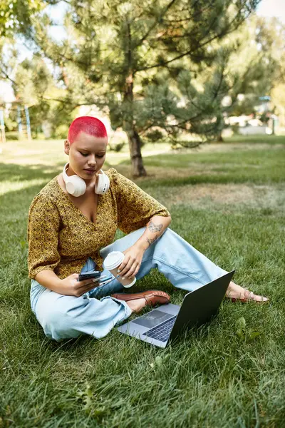 A young woman enjoys the serenity of a park while working on her laptop surrounded by nature. — Stock Photo