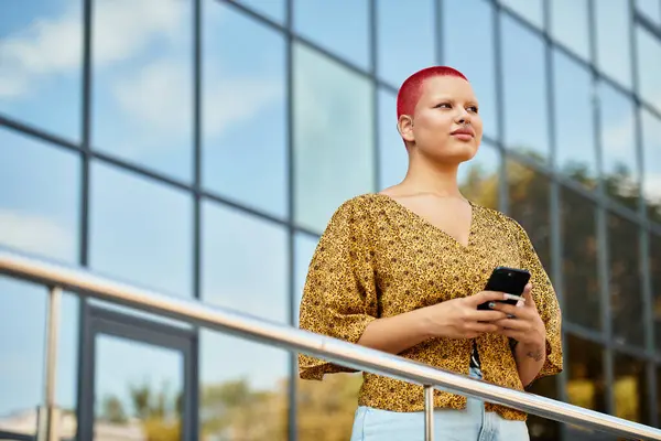 A stunning woman with a bald head and colorful hair enjoys the outdoors with her phone. — Stock Photo