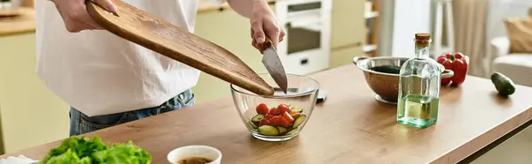 A young man mixes fresh ingredients in a bowl, embracing a healthy kitchen lifestyle. — Stock Photo