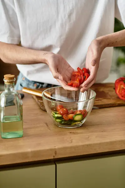 A young man skillfully making a vibrant salad in a contemporary kitchen, embracing healthy living. — Stock Photo