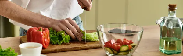 In einer modernen Küche kocht ein hübscher junger Mann gekonnt einen lebendigen Salat für ein gesundes Leben. — Stockfoto