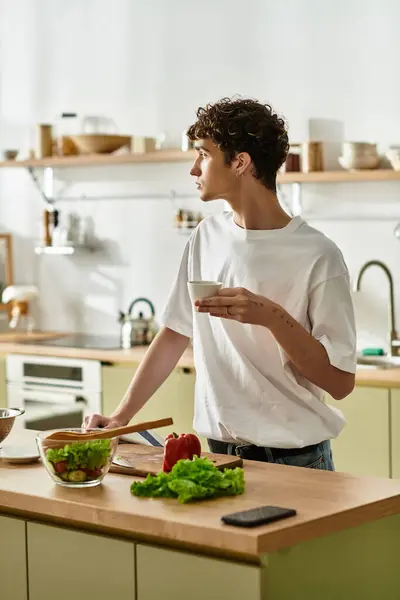 Un beau jeune homme dans une cuisine lumineuse aime le café, embrassant une alimentation saine et un mode de vie. — Photo de stock