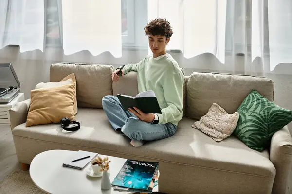 The handsome young man relaxes while reading a book in his stylish home, surrounded by contemporary decor. — Stock Photo