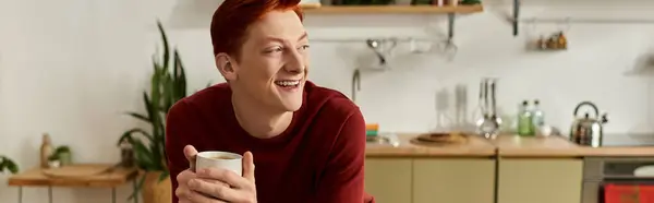 A cheerful young man holds a warm drink, reveling in the festive spirit of the season. — Stock Photo