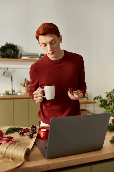 The young man in a cozy setting savors cookies and coffee, embracing the holiday spirit. — Stock Photo