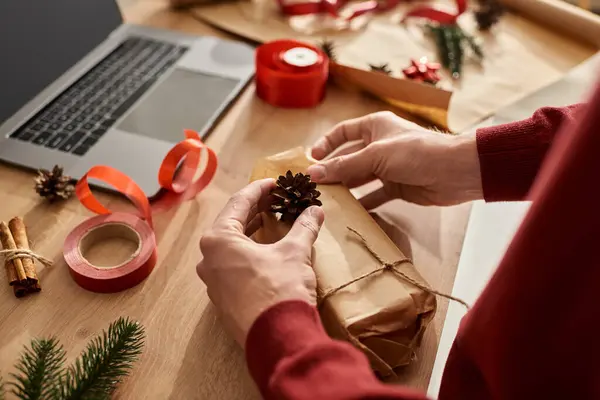 The young man carefully prepares beautifully wrapped gifts, embracing the holiday spirit. — Stock Photo