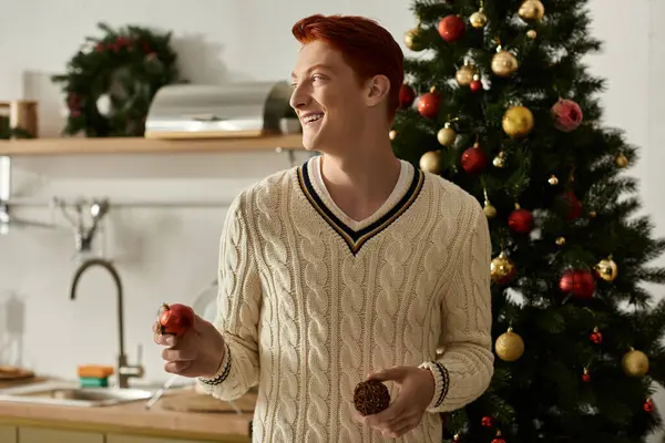 The young man enjoys festive moments as he prepares decorations for Christmas with joy and laughter. — Stock Photo