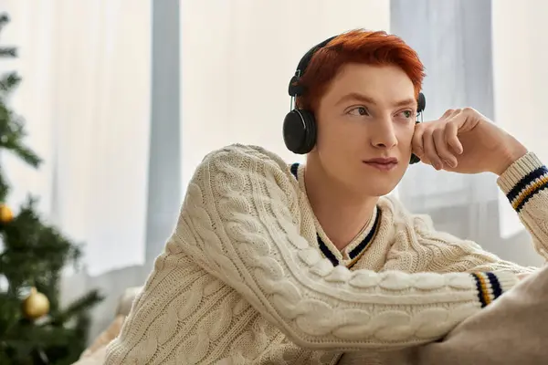 Ein junger Mann entspannt sich in festlicher Atmosphäre, trägt Kopfhörer und genießt Musik. — Stockfoto