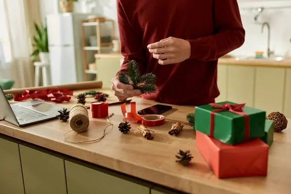 A young man is crafting festive Christmas decorations in a warm, inviting kitchen. — Stock Photo