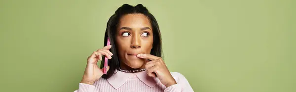 A stylish young woman engages in a lively phone conversation while wearing cozy autumn attire. — Stock Photo