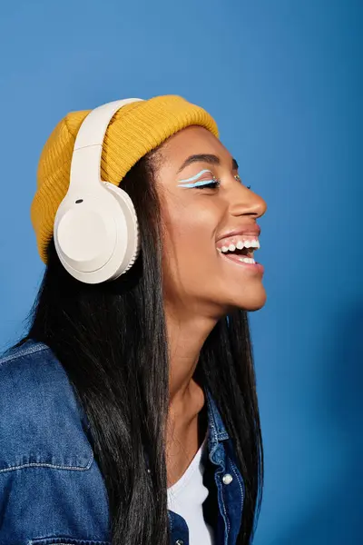 A young woman happily listens to music, showcasing her joyful expression and trendy autumn look. — Stock Photo