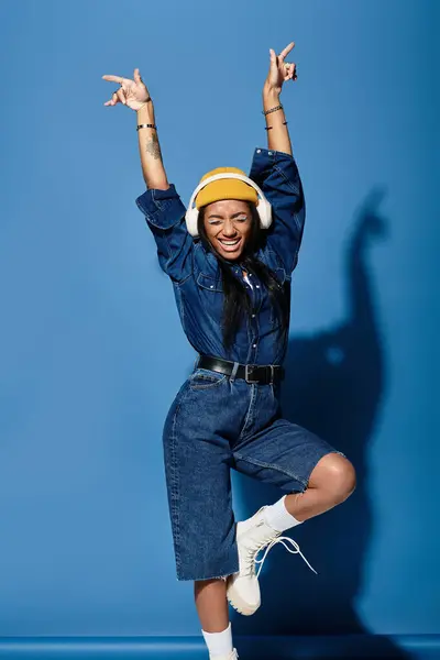 The young woman joyfully poses in warm autumn attire, showcasing vibrant style and energy. — Stock Photo