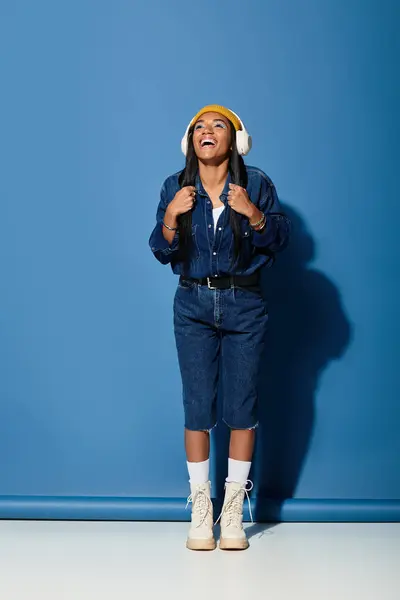 A young woman enjoys the moment, dressed in trendy autumn attire with headphones on. — Stock Photo