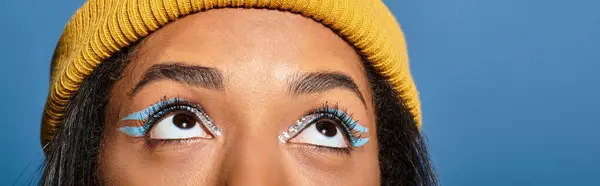Una mujer joven con estilo mira hacia arriba, destacando su maquillaje único y atuendo de otoño. — Stock Photo