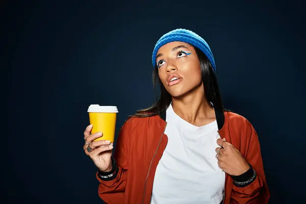 The young woman confidently showcases her warm autumn fashion while sipping coffee. — Stock Photo