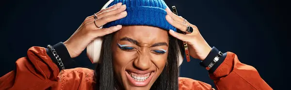 A young woman delightedly listens to music while dressed warmly for autumn, radiating happiness. — Stock Photo