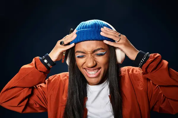 A stylish young woman in autumn attire expresses happiness while listening to music. — Stock Photo