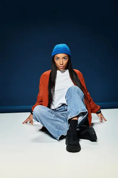 A young woman expresses her fashion sense with autumn attire in a modern indoor environment. — Stock Photo