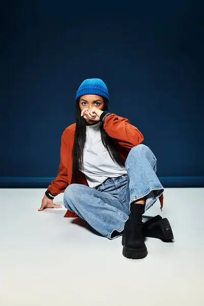 In a stylish pose, a young woman dressed in warm autumn attire sets a cozy indoor mood. — Stock Photo