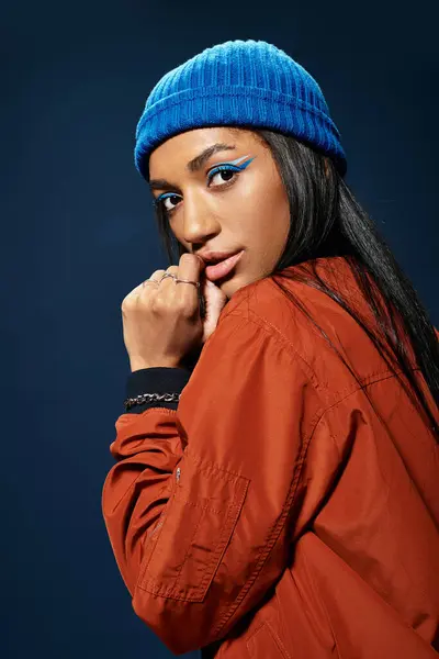 A young woman in warm autumn clothing poses confidently, accentuating her bold style. — Stock Photo