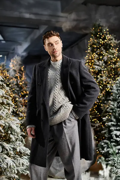 A dapper gentleman dressed in winter attire stands gracefully among snowy pine trees, celebrating the holiday spirit. — Stock Photo