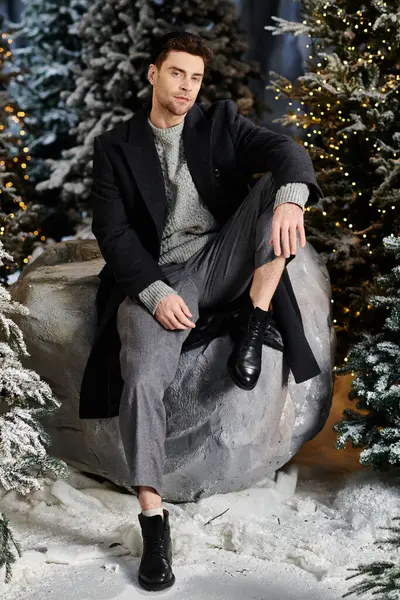 A cheerful man in winter attire enjoys the festive atmosphere surrounded by snow-laden pine trees. — Stock Photo