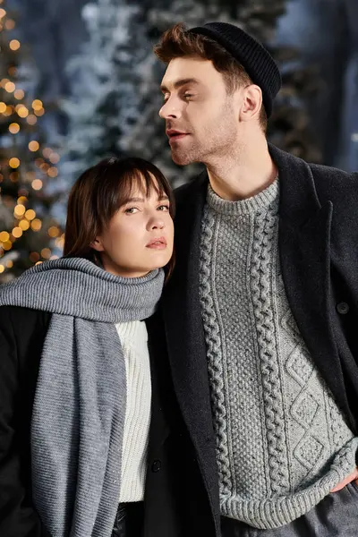 Couple embraces the winter chill, sharing warmth amidst snow-covered pine trees during the holiday season. — Stock Photo