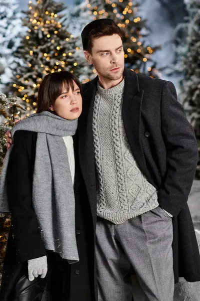 A loving couple stands close, wrapped in warmth amidst the snowy pines, celebrating Christmas cheerfully. — Stock Photo