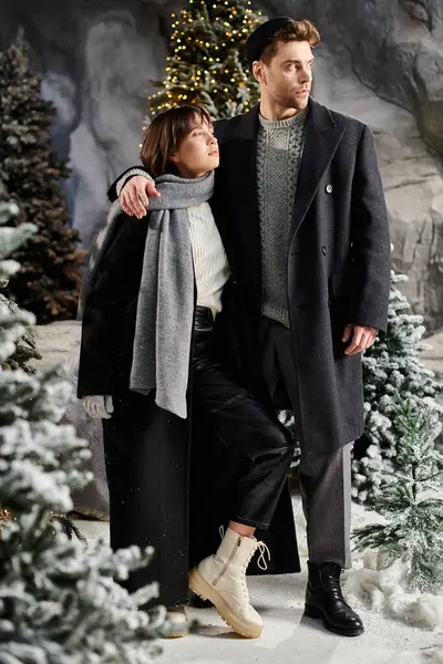 A couple embraces warmly amid snow-laden pine trees, basking in the holiday spirit of Christmas and New Year. — Stock Photo