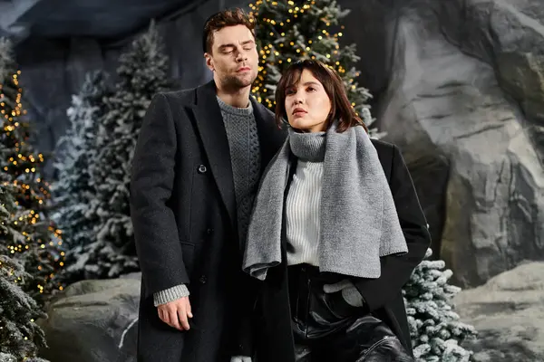 Winter magic envelops this couple as they celebrate love and the festive season near snow-laden pines. — Stock Photo