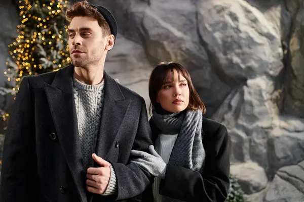 A couple embraces the festive season, enjoying each others warmth amidst snowy pines and holiday cheer. — Stock Photo