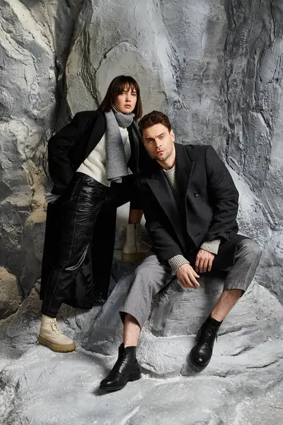 Un couple en manteaux d'hiver partage un moment entouré de rochers — Photo de stock