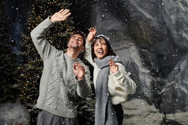 A cheerful couple enjoys the winter wonderland, surrounded by snow and the holiday spirit in the forest. — Stock Photo