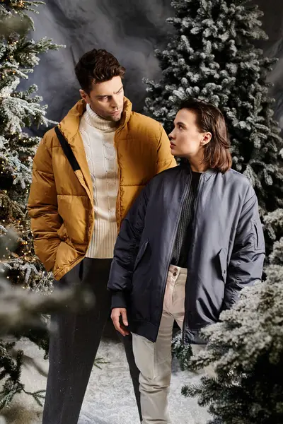A couple enjoys the festive season, surrounded by snow-dusted pine trees, radiating warmth and joy together. — Stock Photo