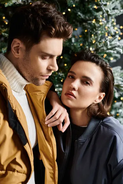 Dans un pays des merveilles hivernal, un couple partage un moment tendre entouré de pins enneigés, célébrant Noël. — Photo de stock