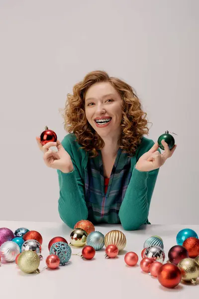 A young woman is happily preparing colorful decorations for the holiday while smiling. — Stock Photo