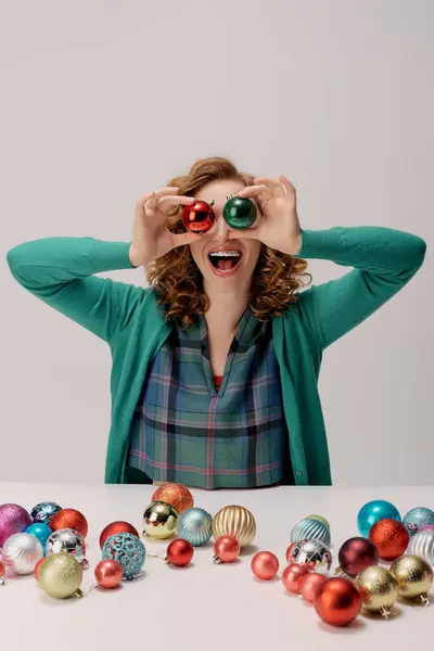 A cheerful young woman is having fun posing cheerfully, cheerful decorations scattered around her. — Stock Photo