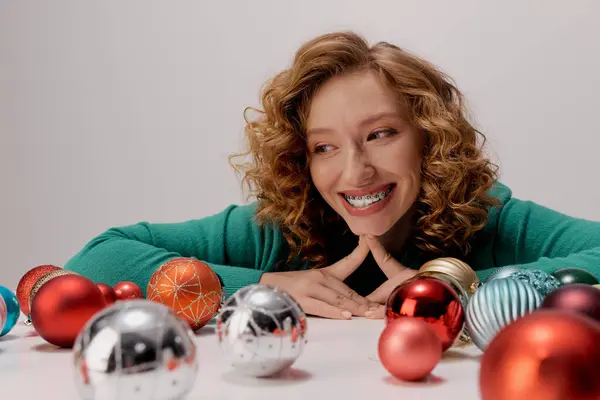 A young woman with curly hair smiles as she celebrating. — Stock Photo