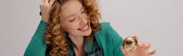 A cheerful young woman with curly hair during a celebration. — Stock Photo