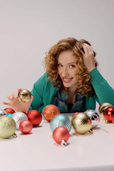 The young woman is excitedly preparing gifts while playfully engaging with beautiful ornaments. — Stock Photo