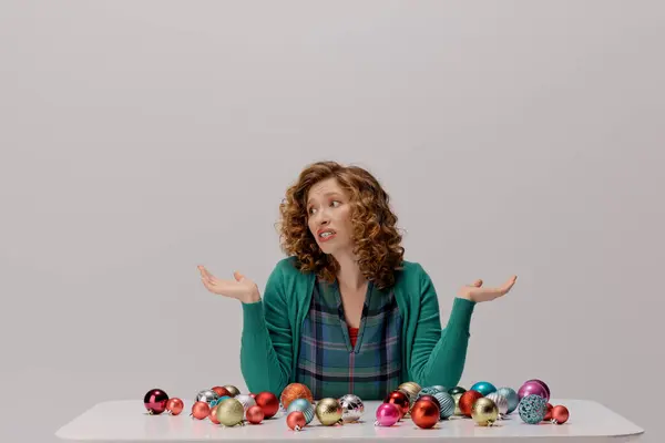 A young woman with curly hair is cheerfully posing cheerfully surrounded by vibrant ornaments. — Stock Photo