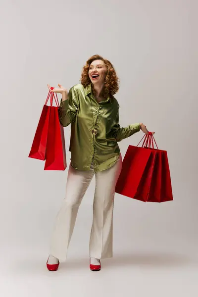 A joyful young woman posing cheerfully in stylish attire, showcasing her creativity. — Stock Photo